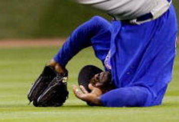 HOUSTON - APRIL 06:  Milton Bradley #21 of the Chicago Cubs flips over after missing a fly ball against the Houston Astros on Opening Day on April 6, 2009 at Minute Maid Park in Houston, Texas.  The Cubs defeated the Astros 4-2.  (Photo by Chris Graythen/Getty Images)