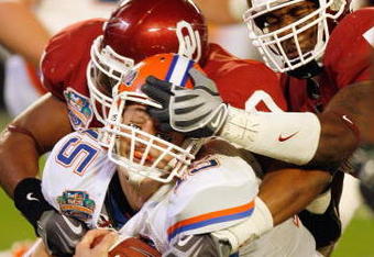 MIAMI - JANUARY 08:  Quarterback Tim Tebow #15 of the Florida Gators gets a facemask as he is sacked against the Oklahoma Sooners during the FedEx BCS National Championship Game at Dolphin Stadium on January 8, 2009 in Miami, Florida.  (Photo by Eliot J. Schechter/Getty Images