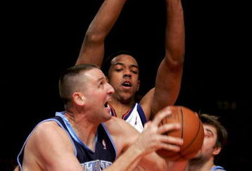 NEW YORK - DECEMBER 23:  Greg Ostertag #00 of the Utah Jazz tries to shoot over Channing Frye #7 of the New York Knicks on December 23, 2005 at Madison Square Garden in New York City. NOTE TO USER: User expressly acknowledges and agrees that, by downloading and or using this photograph, User is consenting to the terms and conditions of the Getty Images License Agreement.  (Photo by Ezra Shaw/Getty Images)