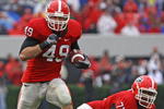 ATHENS, GA - NOVEMBER 29:  Fullback Shaun Chapas #49 of the Georgia Bulldogs runs upfield as teammate and offensive lineman Cordy Glenn watches during the game against the Georgia Tech Yellow Jackets at Sanford Stadium on November 29, 2008 in Athens, Georgia.  The Yellow Jackets defeated the Bulldogs 45-42.  (Photo by Mike Zarrilli/Getty Images)