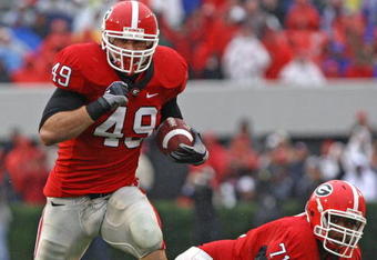 ATHENS, GA - NOVEMBER 29:  Fullback Shaun Chapas #49 of the Georgia Bulldogs runs upfield as teammate and offensive lineman Cordy Glenn watches during the game against the Georgia Tech Yellow Jackets at Sanford Stadium on November 29, 2008 in Athens, Georgia.  The Yellow Jackets defeated the Bulldogs 45-42.  (Photo by Mike Zarrilli/Getty Images)