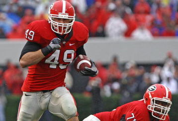ATHENS, GA - NOVEMBER 29:  Fullback Shaun Chapas #49 of the Georgia Bulldogs runs upfield as teammate and offensive lineman Cordy Glenn watches during the game against the Georgia Tech Yellow Jackets at Sanford Stadium on November 29, 2008 in Athens, Georgia.  The Yellow Jackets defeated the Bulldogs 45-42.  (Photo by Mike Zarrilli/Getty Images)