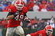 ATHENS, GA - NOVEMBER 29: Fullback Shaun Chapas #49 of the Georgia Bulldogs runs upfield as teammate and offensive lineman Cordy Glenn watches during the game against the Georgia Tech Yellow Jackets at Sanford Stadium on November 29, 2008 in Athens, Georgia. The Yellow Jackets defeated the Bulldogs 45-42. (Photo by Mike Zarrilli/Getty Images)