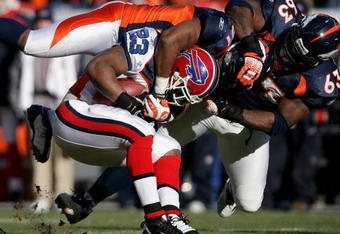 DENVER - DECEMBER 21:  Running back Marshawn Lynch #23 of the Buffalo Bills is tackled by Jamie Winborn #51 and Dewayne Robertson #63 of the Denver Broncos during NFL action at Invesco Field at Mile High on December 21, 2008 in Denver, Colorado. The Bills defeated the Broncos 30-23.  (Photo by Doug Pensinger/Getty Images)