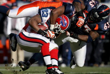 DENVER - DECEMBER 21:  Running back Marshawn Lynch #23 of the Buffalo Bills is tackled by Jamie Winborn #51 and Dewayne Robertson #63 of the Denver Broncos during NFL action at Invesco Field at Mile High on December 21, 2008 in Denver, Colorado. The Bills defeated the Broncos 30-23.  (Photo by Doug Pensinger/Getty Images)