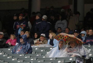 CLEVELAND - APRIL 10:  Fans find cover during a rain delay in the Cleveland Indians and Toronto Blue Jays game April 10, 2009 at Progressive Field in Cleveland, Ohio.  (Photo by Matt Sullivan/Getty Images)