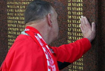 LIVERPOOL, ENGLAND - APRIL 11:  A Liverpool fan pays his respects to those who died in the Hillsborough disaster prior to the during the Barclays Premier League match obetween Liverpool and Blackburn at Anfield on April 11, 2009 in Liverpool, England.  On April 15 it will be the 20th anniversary of the Hillsborough disaster, the bells of Liverpools two cathedrals will ring 96 times in memory of the 96 fans who lost their lives. At 3:06pm, exactly 20 years since the match was abandoned Liverpools public transport will stop for 2 minutes. There will also be a memorial service on the Kop where 96 candles will be lit and a representative from each family will be awarded the freedom of the city.  (Photo by Clive Rose/Getty Images)