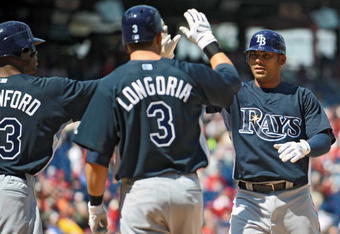 PHILADELPHIA - APRIL 4: First baseman Carlos Pena #23 of the Tampa Bay Rays gets congratulated by teammates left fielder Carl Crawford #13 and third baseman Evan Longoria #3 after hitting a 3 run home-run in the top of the first inning during the game against the Philadelphia Phillies on April 4, 2009 at Citizens Bank Park in Philadelphia, Pennsylvania.  The Rays won 9-7. (Photo by Drew Hallowell/Getty Images)