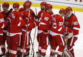 DETROIT - APRIL 26: Chris Osgood #30 of the Detroit Red Wings is congratulated by Kris Draper #33 after a 5-1 victory over the Colorado Avalanche in game two of the Western Conference Quarterfinals of the 2008 NHL Stanley Cup Playoffs on April 26, 2008 at Joe Louis Arena in Detroit, Michigan.  (Photo by Gregory Shamus/Getty Images)  