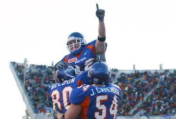 BOISE, ID - NOVEMBER 20:  Running back Jon Helmandollar #33 of Boise State is hoisted up by teammates Andy Weldon #80 and Jeff Cavender #54 after scoring a touchdown in the fourth quarter against Louisiana Tech at Bronco Stadium on November 20, 2004 in Boise, Idaho. Boise State defeated Louisiana Tech 55-14. (Photo by Jeff Gross/Getty Images)