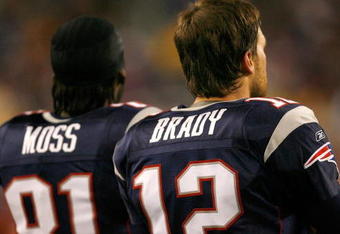 FOXBOROUGH, MA - DECEMBER 23: Randy Moss #81 and Tom Brady #12 of the New England Patriots stand on the sideline against the Miami Dolphins at Gillette Stadium on December 23, 2007 in Foxborough, Massachusetts. Patriots won 28-7. (Photo by Jim Rogash/Getty Images)