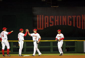 WASHINGTON - APRIL 14: (L-R) Nick Johnson #24 Vinny Castilla #9, Ryan Church #19 and Terrmel Sledge #19 of the Washington Nationals celebrate after beating the Arizona Diamondbacks 5-3 during the Nationals home opener April 14, 2005 at RFK Stadium in Washington, DC. (Photo by Jamie Squire/Getty Images)