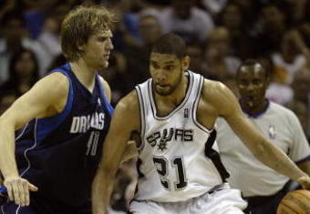 AN ANTONIO - MAY 09: Tim Duncan #21 of the San Antonio Spurs moves the ball against Dirk Nowitzki #41 in Game two of the Western Conference Semifinals against the Dallas Mavericks during the 2006 NBA Playoffs on May 9, 2006 at the AT&T Center in San Antonio, Texas. The Mavericks won 113-91 to tie the series 1-1. NOTE TO USER: User expressly acknowledges and agrees that, by downloading and or using this photograph, User is consenting to the terms and conditions of the Getty Images License Agreement. (Photo by Ronald Martinez/Getty Images)