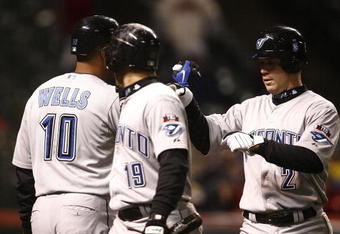 CLEVELAND - APRIL 10: Marco Scutaro #19 of the Toronto Blue Jays celebrates with Aaron Hill  #2 and  Vernon Wells #10 after scoring against the Cleveland Indians in the seventh inning April 10, 2009 at Progressive Field in Cleveland, Ohio.  (Photo by Matt Sullivan/Getty Images)