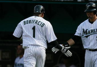 MIAMI - APRIL 06:  Emilio Bonifacio #1 of the Florida Marlins is congratulated by Jorge Cantu #3 after scoring in the thrid inning against the Washington Nationals on opening day at Dolphin Stadium on April 6, 2009 in Miami, Florida.  (Photo by Doug Benc/Getty Images)