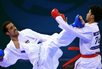 DOHA, QATAR - DECEMBER 13:  Kushal Shresta (R) of Nepal receives a kick to the face from Fadi Al Najjar (L) of Jordan during the Men's Karate 65kg preliminary round match during the 15th Asian Games Doha 2006 at The Qatar Sports Club Indoor Hall, Dedcember13, 2006 in Doha, Qatar.  (Photo by Jamie Squire/Getty Images)