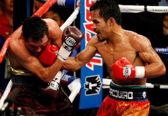 LAS VEGAS - DECEMBER 06:  (R-L) Manny Pacquiao of the Philippines connects with a right to the head of Oscar De La Hoya during their welterweight fight at the MGM Grand Garden Arena December 6, 2008 in Las Vegas, Nevada.  (Photo by Ethan Miller/Getty Images)