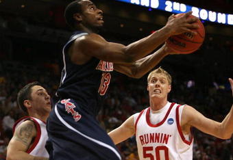 MIAMI - MARCH 20:  Guard Nic Wise #13 (C) of the University of Arizona Wildcats drives to the basket past guard Tyler Kepkay #32 (L) and center Luke Nevill #50 (R) of the University of Utah Runnin' Utes during the first round of the NCAA Division I Men's Basketball Tournament at the American Airlines Arena on March 20, 2009 in Miami, Florida.  (Photo by Marc Serota/Getty Images);  (Photo by Marc Serota/Getty Images)