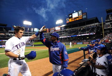 ARLINGTON, TX - APRIL 15:  Ian Kinsler #5 of the Texas Rangers celebrates a solo homerun with manager Ron Washington while wearing jersey #42 to commemorate Jackie Robinson day during a game against the Baltimore Orioles on April 15, 2009 at Rangers Ballpark in Arlington, Texas.  (Photo by Ronald Martinez/Getty Images)