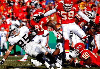 KANSAS CITY, MO - NOVEMBER 25:  Justin Fargas #25 of the Oakland Raiders carries the ball as Napoleon Harris #50 and Donnie Edwards #59 of the Kansas City Chiefs defend during the game on November 25, 2007 at Arrowhead Stadium in Kansas City, Missouri.  (Photo by Jamie Squire/Getty Images)
