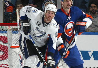 UNIONDALE, NY - APRIL 04: Ryan Malone #12 of the Tampa Bay Lightning in front of the net with Radek Martinek #24 of the New York Islanders in a National Hockey League game at Nassau Coliseum on April 4, 2009 in Uniondale, New York. (Photo by Paul Bereswill/Getty Images)
