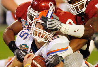 MIAMI - JANUARY 08:  Quarterback Tim Tebow #15 of the Florida Gators gets a facemask as he is sacked against the Oklahoma Sooners during the FedEx BCS National Championship Game at Dolphin Stadium on January 8, 2009 in Miami, Florida.  (Photo by Eliot J. Schechter/Getty Images