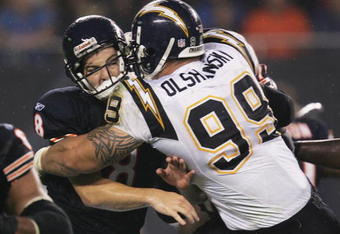 CHICAGO - AUGUST 18:   Igor Olshansky #99 of the San Diego Chargers hits Rex Grossman #8 of the Chicago Bears after a pass during a game on August 18, 2006 at Soldier Field in Chicago, Illinois.  (Photo by Jonathan Daniel/Getty Images)