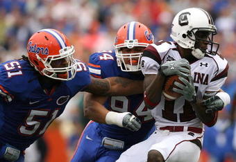 GAINESVILLE, FL - NOVEMBER 15:  Linebacker Brandon Spikes #51 and defensive end Justin Trattou #94 of the Florida Gators bring down wide receiver Kenny McKinley #11 of the South Carolina Gamecocks at Ben Hill Griffin Stadium on November 15, 2008 in Gainesville, Florida.  (Photo by Doug Benc/Getty Images)