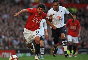 MANCHESTER, ENGLAND - APRIL 25:  Carlos Tevez of Manchester United holds off Benoit Assou-Ekotto of Tottenham Hotspur during the Barclays Premier League match between Manchester United and Tottenham Hotspur at Old Trafford on April 25, 2009 in Manchester, England.  (Photo by Shaun Botterill/Getty Images)