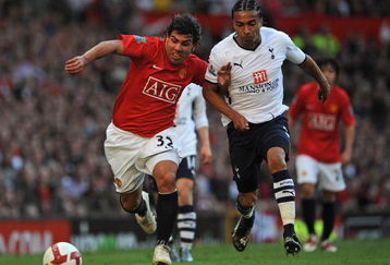 MANCHESTER, ENGLAND - APRIL 25:  Carlos Tevez of Manchester United holds off Benoit Assou-Ekotto of Tottenham Hotspur during the Barclays Premier League match between Manchester United and Tottenham Hotspur at Old Trafford on April 25, 2009 in Manchester, England.  (Photo by Shaun Botterill/Getty Images)