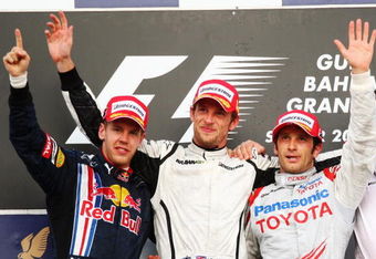 SAKHIR, BAHRAIN - APRIL 26:  Race winner Jenson Button (C) of Great Britain and Brawn GP, second placed Sebastian Vettel (L) of Germany and Red Bull Racing and third placed Jarno Trulli (R) of Italy and Toyota celebrate on the podium following the Bahrain Formula One Grand Prix at the Bahrain International Circuit on April 26, 2009 in Sakhir, Bahrain.  (Photo by Clive Mason/Getty Images)
