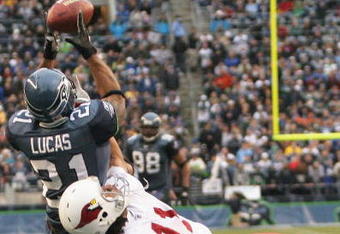 SEATTLE - DECEMBER 26:  Ken Lucas #21 of the Seattle Seahawks intercepts this pass in the end zone against Wide Receiver Larry Fitzgerald #11 of the Arizona Cardinals at Qwest Field December 26, 2004 in Seattle, Washington. (Photo by Otto Greule Jr/Getty Images)