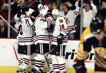 CHICAGO - DECEMBER 29:  Fans and members of the Chicago Blackhawks including James Wisniewski #43, Martin Lapointe #22 and Radim Vrbata #16 celebrate a goal with teammate Denis Arkhipov #19 in the 3rd period as Marc Savard #91 of the Boston Bruins skates away on December 29, 2006 at the United Center in Chicago, Illinois. The Bruins defeated the Blackhawks 5-3. (Photo by Jonathan Daniel/Getty Images)