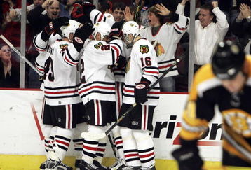 CHICAGO - DECEMBER 29:  Fans and members of the Chicago Blackhawks including James Wisniewski #43, Martin Lapointe #22 and Radim Vrbata #16 celebrate a goal with teammate Denis Arkhipov #19 in the 3rd period as Marc Savard #91 of the Boston Bruins skates away on December 29, 2006 at the United Center in Chicago, Illinois. The Bruins defeated the Blackhawks 5-3. (Photo by Jonathan Daniel/Getty Images)