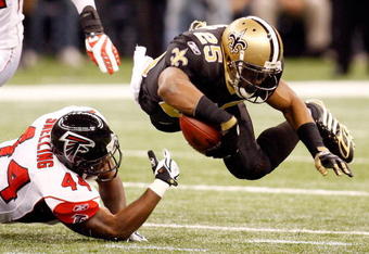 NEW ORLEANS - DECEMBER 07:  Reggie Bush #25 of the New Orleans Saints is tripped by Jason Snelling #44 of the Atlanta Falcons on December 7, 2008 at the Superdome in New Orleans, Louisiana.  (Photo by Chris Graythen/Getty Images)