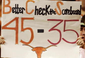 AUSTIN, TX - NOVEMBER 27:  A Texas Longhorn fan cheers on her team against the Texas A&M Aggies while holding a reminder of the Texas score against Oklahoma earlier in the season at Darrell K Royal-Texas Memorial Stadium November 27, 2008 in Austin, Texas.  (Photo by Brian Bahr/Getty Images)