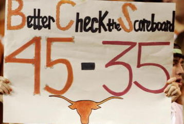 AUSTIN, TX - NOVEMBER 27:  A Texas Longhorn fan cheers on her team against the Texas A&M Aggies while holding a reminder of the Texas score against Oklahoma earlier in the season at Darrell K Royal-Texas Memorial Stadium November 27, 2008 in Austin, Texas.  (Photo by Brian Bahr/Getty Images)