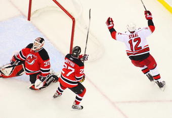 NEWARK, NJ - APRIL 28:   Eric Staal #12 of the Carolina Hurricanes celebrates after his game-winning goal at 19:28 in the third period against goaltender Martin Brodeur #30 and Mike Mottau #27 of the New Jersey Devils during Game Seven of the Eastern Conference Quarterfinal Round of the 2009 Stanley Cup Playoffs at the Prudential Center on April 28, 2009 in Newark, New Jersey. Tghe Hurricanes defeat the Devils 4-3  (Photo by Mike Stobe/Getty Images)