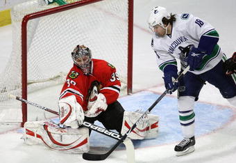 CHICAGO - MARCH 29: Nikolai Khabibulin #39 of the Chicago Blackhawks turns back a shot by Steve Bernier #18 of the Vancouver Canucks on March 29, 2009 at the United Center in Chicago, Illinois. The Canucks defeated the Blackhawks 4-0. (Photo by Jonathan Daniel/Getty Images)