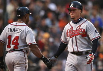 SAN FRANCISCO - JULY 24:  Chipper Jones #10 of the Atlanta Braves is congratulated by Julio Franco #14 after scoring on a double by Jeff Francoeur in the fourth inning against the San Francisco Giants at AT&T Park July 24, 2007 in San Francisco, California.   (Photo by Jed Jacobsohn/Getty Images)