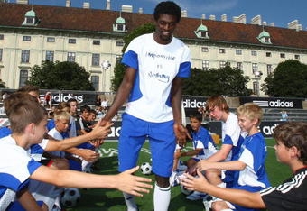 VIENNA, AUSTRIA - JUNE 27:  Emmanuel Adebayor welcomes children at the Fan Park during the UEFA EURO 2008 Adidas Photocall on June 27, 2008 in Vienna, Austria. (Photo by Andreas Rentz/Getty Images for adidas)