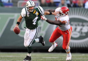 EAST RUTHERFORD, NJ - OCTOBER 26:  Brett Favre #4 of the New York Jets eludes a sack by Tamba Hali #91 of the Kansas City Chiefs during their game on October 26, 2008 at Giants Stadium in East Rutherford, New Jersey.  (Photo by Al Bello/Getty Images)