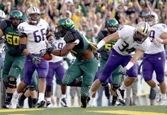EUGENE, OR - AUGUST 30:  LaMichael James #21 of the Oregon Ducks carries the ball as he is grabbed by Tripper Johnson #34 of the Washington Huskies at Autzen Stadium on August 30, 2008 in Eugene, Oregon. (Photo by Jonathan Ferrey/Getty Images)