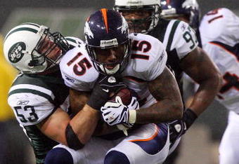 EAST RUTHERFORD, NJ - NOVEMBER 30:  Brandon Marshall #15 of the Denver Broncos is tackled by Cody Spencer #53 of the New York Jets on November 30, 2008 at Giants Stadium in East Rutherford, New Jersey. The Broncos defeated the Jets 34-17.  (Photo by Jim McIsaac/Getty Images)