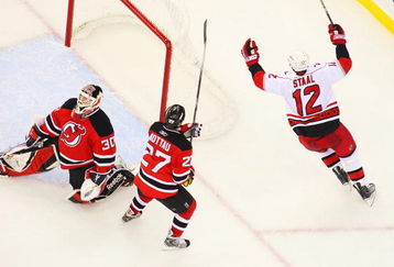 NEWARK, NJ - APRIL 28:   Eric Staal #12 of the Carolina Hurricanes celebrates after his game-winning goal at 19:28 in the third period against goaltender Martin Brodeur #30 and Mike Mottau #27 of the New Jersey Devils during Game Seven of the Eastern Conference Quarterfinal Round of the 2009 Stanley Cup Playoffs at the Prudential Center on April 28, 2009 in Newark, New Jersey. Tghe Hurricanes defeat the Devils 4-3  (Photo by Mike Stobe/Getty Images)
