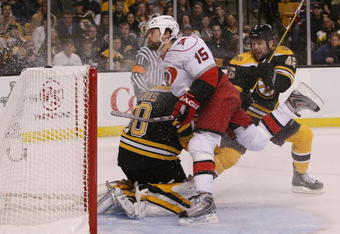 BOSTON - MAY 01:  Tuomo Ruutu #15 of the Carolina Hurricanes is shoved into Tim Thomas #30 of the Boston Bruins by Mark Stuart #45 during Game One of the Eastern Conference Semifinal Round of the 2009 Stanley Cup Playoffs on May 1, 2009 at the TD Banknorth Garden in Boston, Massachusetts. The Bruins defeated the Hurricanes 4-1. (Photo by Elsa/Getty Images)
