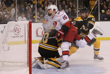 BOSTON - MAY 01:  Tuomo Ruutu #15 of the Carolina Hurricanes is shoved into Tim Thomas #30 of the Boston Bruins by Mark Stuart #45 during Game One of the Eastern Conference Semifinal Round of the 2009 Stanley Cup Playoffs on May 1, 2009 at the TD Banknorth Garden in Boston, Massachusetts. The Bruins defeated the Hurricanes 4-1. (Photo by Elsa/Getty Images)