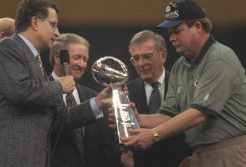 26 Jan 1997:  Head coach Mike Holmgren of the Green Bay Packers (right) receives the Vince Lombardi trophy from NFL commissioner Paul Tagliabue (left) after the Packers beat the New England Patriots 35-21 to win Super Bowl XXXI at the Louisiana Superdome