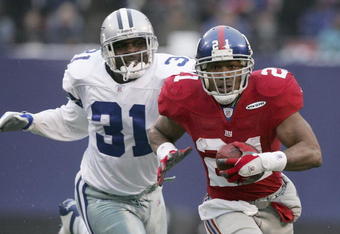 EAST RUTHERFORD, NJ - DECEMBER 04:  Tiki Barber #21 of the New York Giants breaks a tackle by Roy Williams #31 of the Dallas Cowboys during their game at Giants Stadium on December 4, 2005 in East Rutherford, New Jersey.  (Photo by Al Bello/Getty Images)