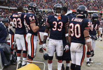 CHICAGO - DECEMBER 07: Adewale Ogunleye #93, Brian Urlacher #54, Charles Tillman #33 and Mike Brown #30 of the Chicago Bears stand in front of heaters to warm up during a game against the Jacksonville Jaguars on December 7, 2008 at Soldier Field in Chicago, Illinois. The Bears defeated the Jaguars 23-10. (Photo by Jonathan Daniel/Getty Images)